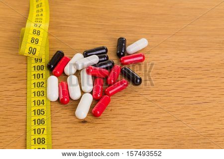 Diet pills on the table. Beautiful figure.