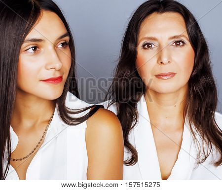 cute pretty teen daughter with mature mother hugging, fashion style brunette makeup close up, real happy family