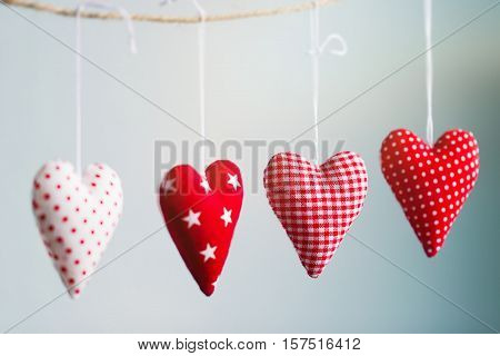 Beautiful red plush hearts hanging on rope with beautiful light on a colorful background horizontal valentine's day or love concept