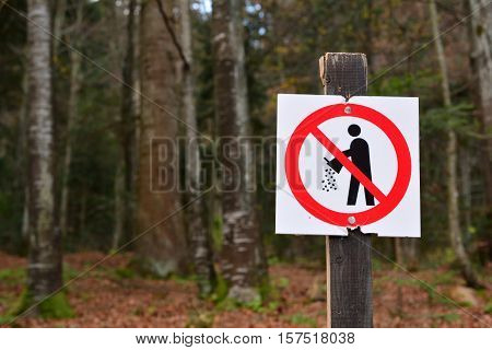 Forbiden littering sign in the forest please keep the environment from pollution