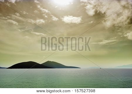 Seascape with dark hills and boat in Norwegian fjord