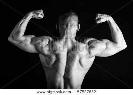 Bodybuilder posing in different poses demonstrating their muscles. Failure on a dark background. Male showing muscles straining. Beautiful muscular body athlete.