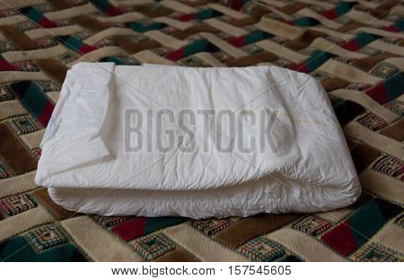 Folded disposable diaper for adults. Nursing care for the bedridden. Hygiene incontinence.