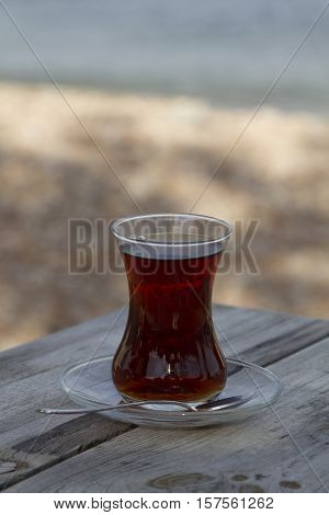 Traditional turkish glass of tea on the old wooden table