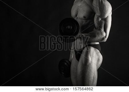 Bodybuilder posing in different poses demonstrating their muscles. Failure on a dark background. Male showing muscles straining. Beautiful muscular body athlete.