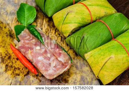 Sour pork Thai northeastern style food which mixed pork rice garlic sugar and salt in banana leaf package.
