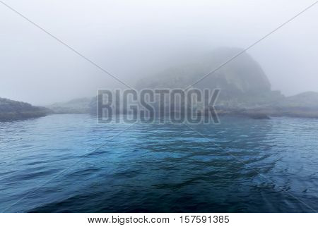 Majestic sea and rocks in heavy fog in Northern Norway