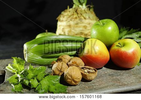 Ingredients for Waldorf salad - celery apples walnuts - fresh and healthy vegetables on granite board.