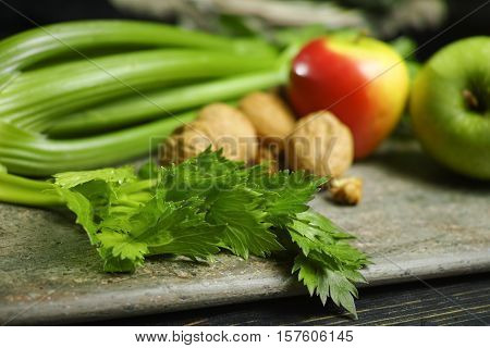 Ingredients for Waldorf salad - celery apples walnuts - fresh and healthy vegetables on granite board.