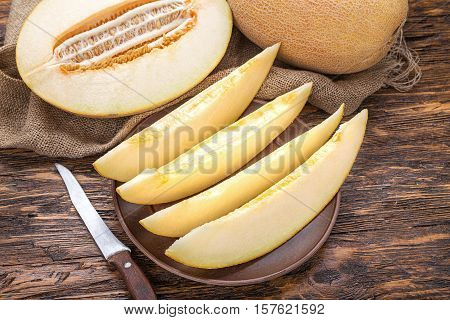juicy ripe cut melon on a dark brown table