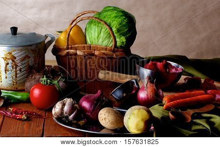 Arrangement of Raw Ingredients with Vegetables Meat Spices and Kitchen Dish Ware closeup on Wooden background. Dutch Still Life Styled