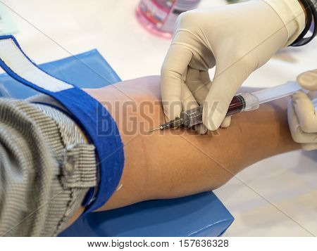 Nurse taking Real Blood samples (Phlebotomist) for analysis from a patient (Selective focus)