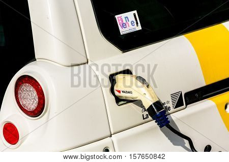 La rochelle France - April 19 2016: Electric Car Being Charged. Charging an electric car with the power supply plugged in.