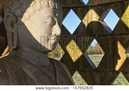 Carved stone buddha statue inside small stupa