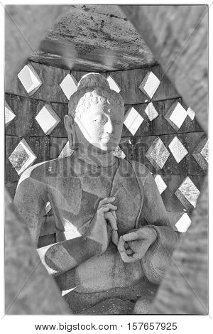 Carved stone buddha statue inside small stupa. Black and white photograph with a vintage border