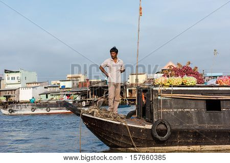 CAN THO, VIETNAM - FEB. 4: Vietnamese man selling produce at the Floating Market in Can Tho, Vietnam on February 4, 2016. Cai Rang Floating Market is the biggest floating market in the Mekong Delta.