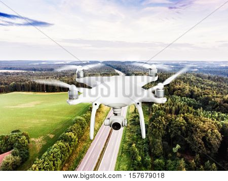 Hovering drone taking pictures of highway in the middle of green forest. Cloudy sky. Netherlands