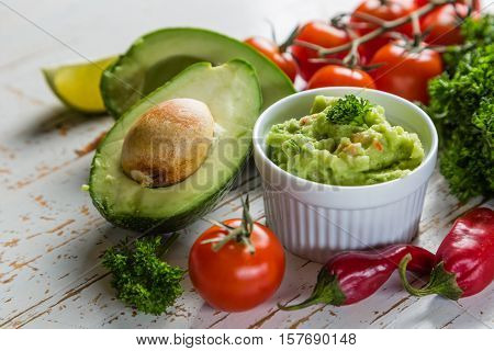 Guacamole sauce and indredients on wood background, copy space