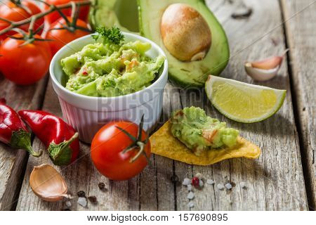 Guacamole sauce and indredients on wood background, copy space