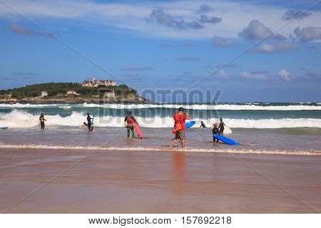 SANTANDER SPAIN - AUGUST 20: Surfers into the sea with surf boards on August 20 2016