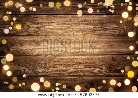Festive rustic wood background with dark vignette and framed by glowing bokeh lights ideal for Christmas advertisement or party