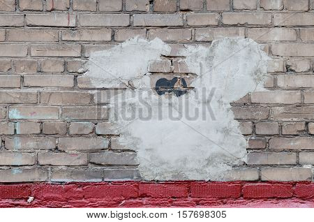 Plastered hole in a wall of gray brick