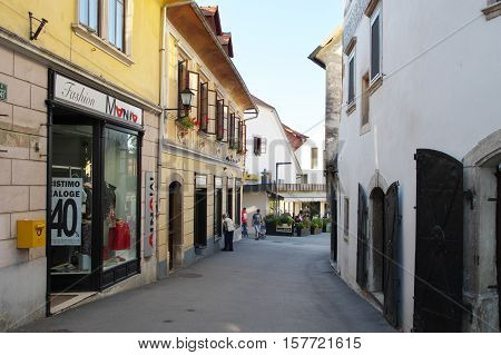 Gmina Škofja Loka, Škofja Loka Slovenia - September 25 2016: old town, Mestni trg. Some people are visible on the street and in the garden pub.