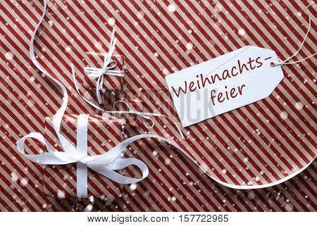 Label With German Text Weihnachtsfeier Means Christmas Party. Two Gifts Or Presents With White Ribbon. Red And Brown Striped Wrapping Paper. Christmas Or Greeting Card With Snowflakes.