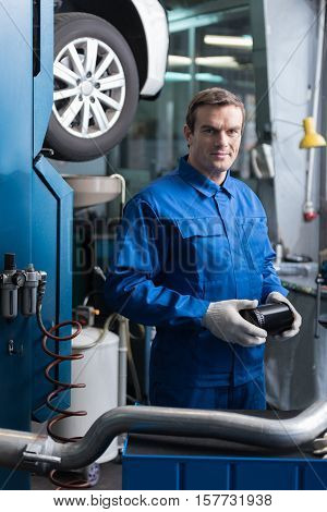 Mans idea. Positive delighted mechanic holding tool and standing near car while going to repair it