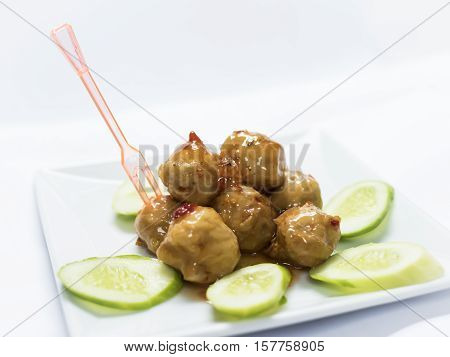 Pork balls with cucumber on the dish.
