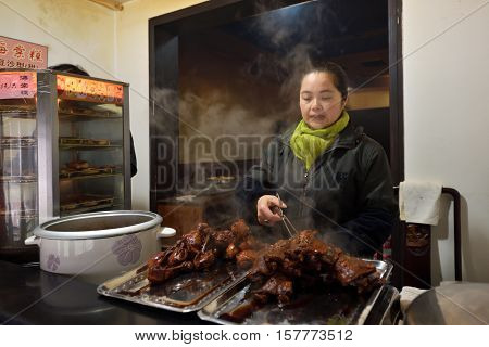 WUZHEN CHINA - MARCH 24: Unidentified Chinese people trade traditional food on March 24 2016 in Wuzhen China. Wuzhen is a historic scenic town located in northern Zhejiang Province China