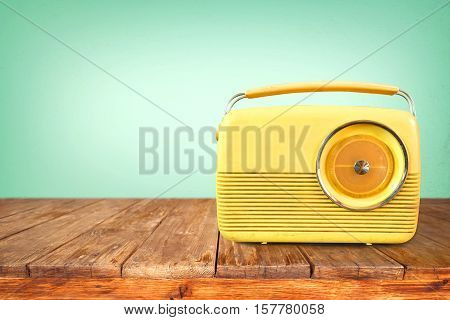 Retro radio on table with vintage green eye light background - old technology