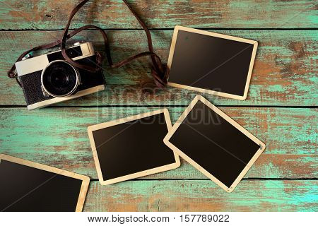 Retro camera and empty old instant paper photo album on wood table - blank photo frame vintage style