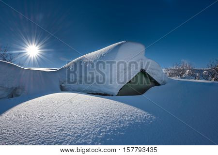 Small house covered with a lot of snow after heavy snowfall in the Alps
