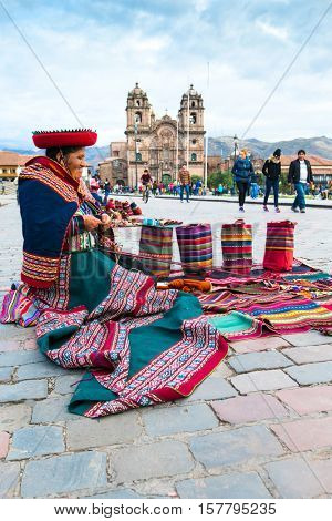  Peru Nov. 9 2015: Unidentified native weavers, dressed in traditional clothing, demonstrate their handicraft. Cusco.