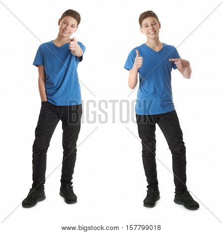 Cute teenager boy in blue T-shirt standing and poinitng forward over white isolated background full body