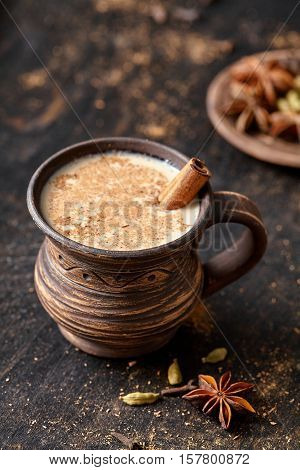 Masala pulled tea chai latte tasty hot Indian sweet milk spiced drink, ginger, fresh spices and herbs blend, anise organic infusion healthy wellness beverage teatime ceremony in rustic clay cup