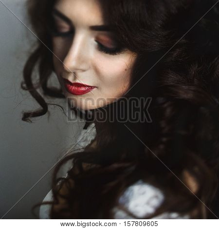 Shining brunette with culy hair dreams before the wedding