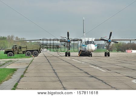 Vasilkov Ukraine - April 24 2012: Ukraine Air Force Antonov An-26 cargo plane is preparing to start the engines with the starter vehicle