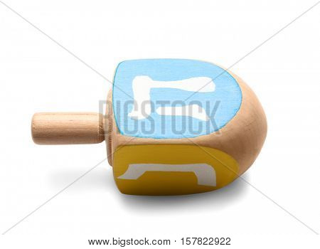 Wooden dreidel for Hanukkah on white background