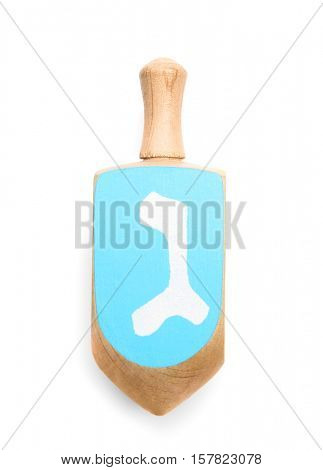 Wooden dreidel for Hanukkah on white background