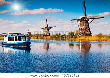 Walking boat on the famous Kinderdijk canal with windmills. Old Dutch village Kinderdijk UNESCO world heritage site. Netherlands Europe.