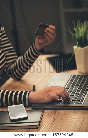 Laptop computer shopping online from office businesswoman using debit payment card to purchase items on internet selective focus