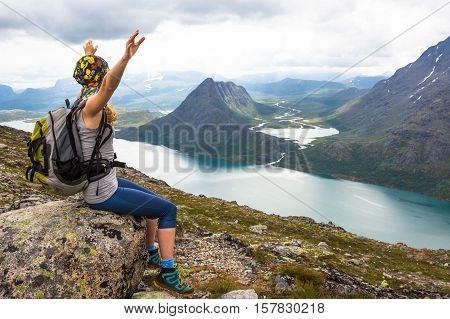 Young woman hiking on Besseggen. Happy girl enjoy lake and good weather in Norway.