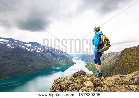 Young woman hiking on Besseggen. Happy girl enjoy lake and good weather in Norway.