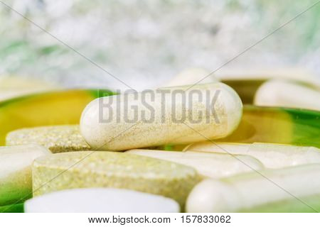 Mixed natural food supplement pills omega 3 multivitamin and glucosamine capsules macro image