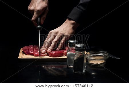 Best receipt. Close up of chefs hands chopping meat while working and cooking in restaurant.