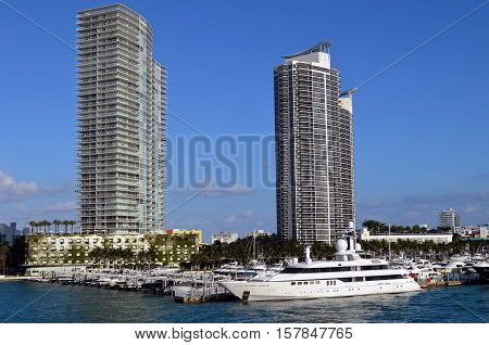 Luxury mega yacht moored at and luxury condo towers overlooking the Miami Beach Marina