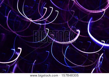 Photo by pink violetblue and white semi-oval light lines to abstract background.