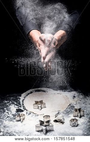 Tasty and sweet. Close up of young mans hands cooking cookies while using bakery mold and working in restaurant.
